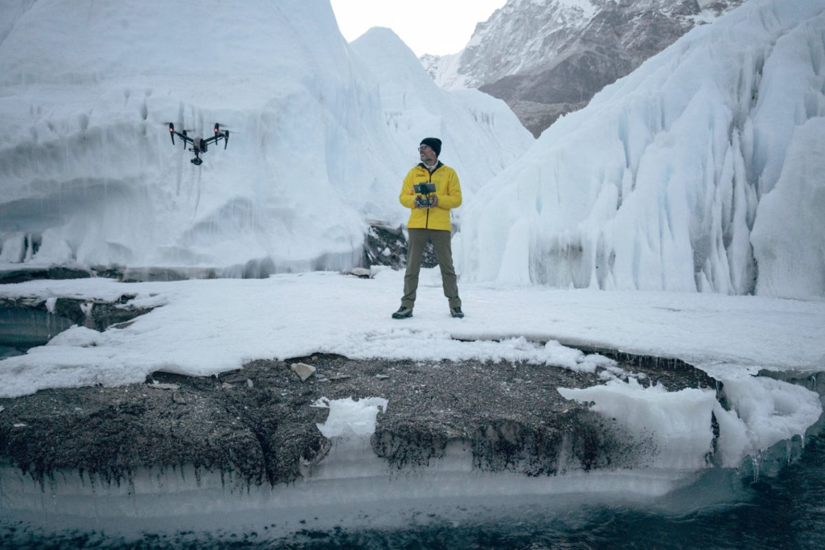 a man and a drone among the ice mountain