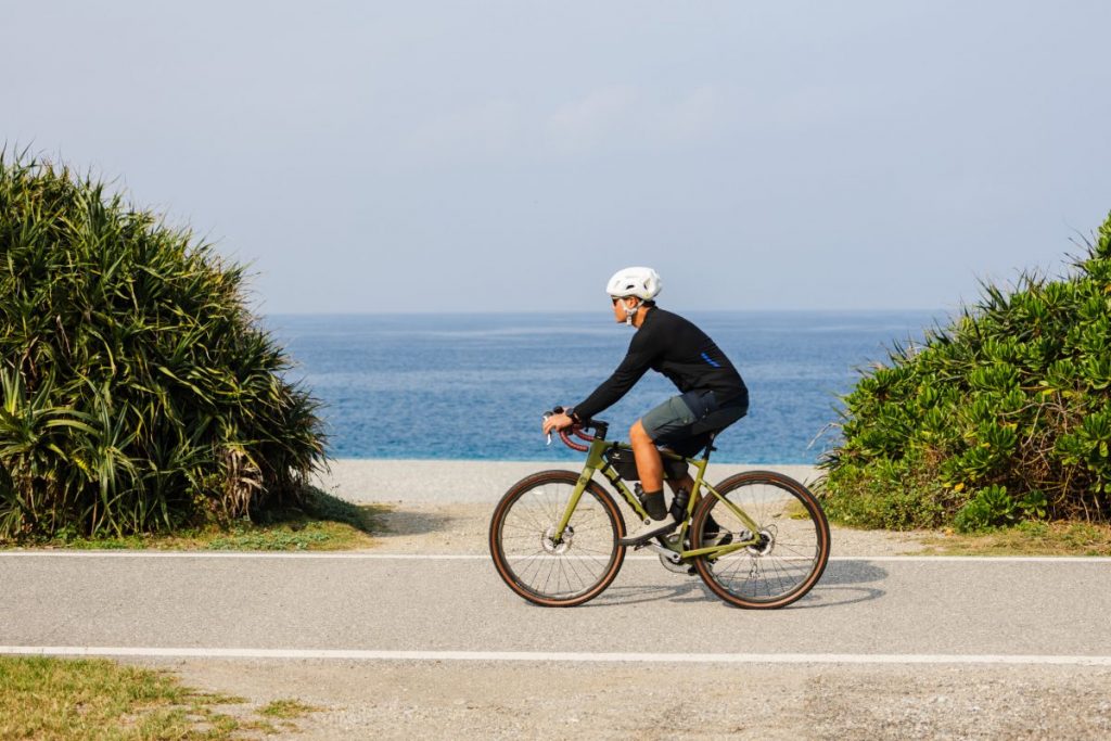 Man is cycling by the beach
