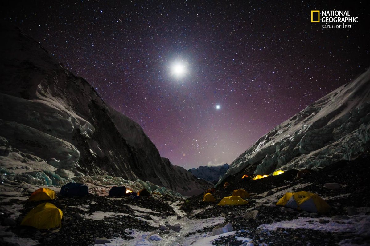 A star-filled sky and bright moon shine over tents on Everest